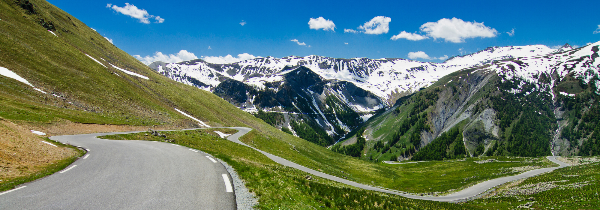Scenic French Alps mountain pass overlooking a wide alpine valley and distant peaks
