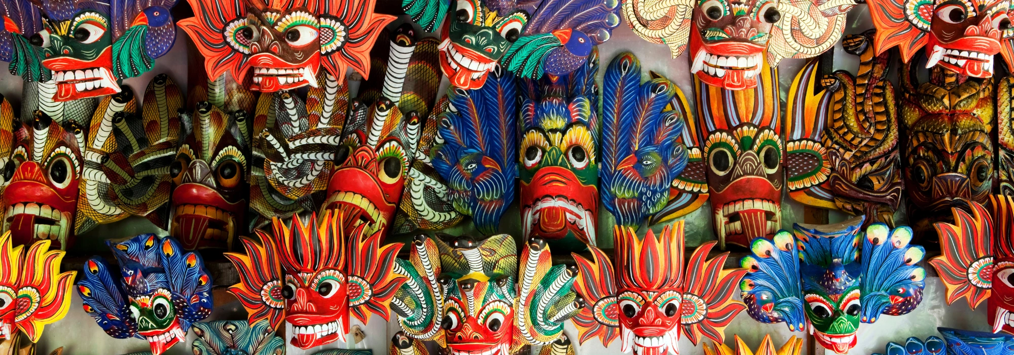Traditional Sri Lankan wooden face masks displayed in vibrant colors, used as a tour page banner.