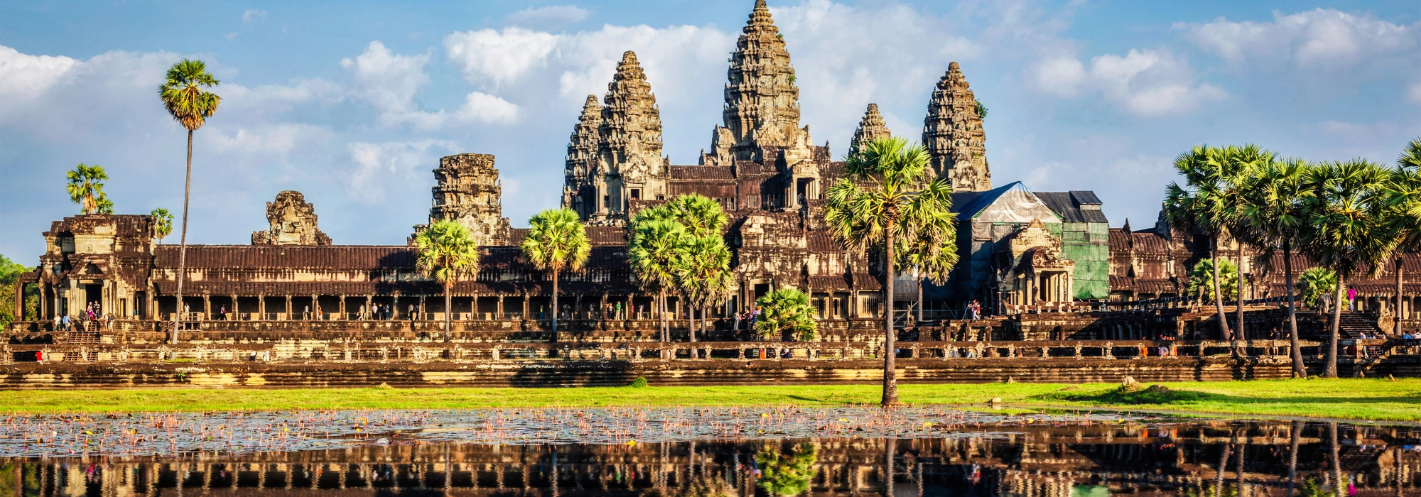 Angkor Wat temple at sunrise in Cambodia, reflected in the surrounding water.